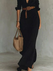 Lower view of a black shirt maxi dress showing the draped skirt and brown belt detail