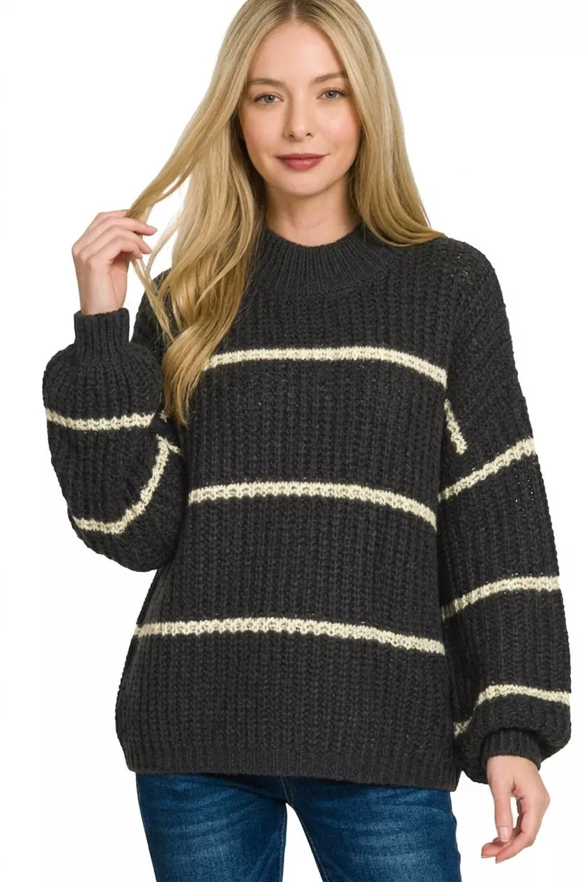 Front view of black oversize striped sweater with cream stripes and dark jeans