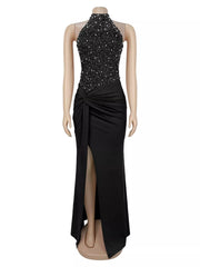 Black sleeveless maxi dress on a mannequin front view with rhinestone halter bodice and front slit