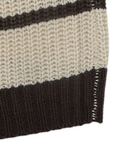 Close up of the brown ribbed hem on a cream and brown striped knit sweater.