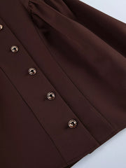 Brown button down mini dress detail showing button placket and flared skirt fabric