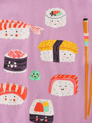 Close-up of the smiling sushi pieces and orange chopsticks on dusty pink fabric
