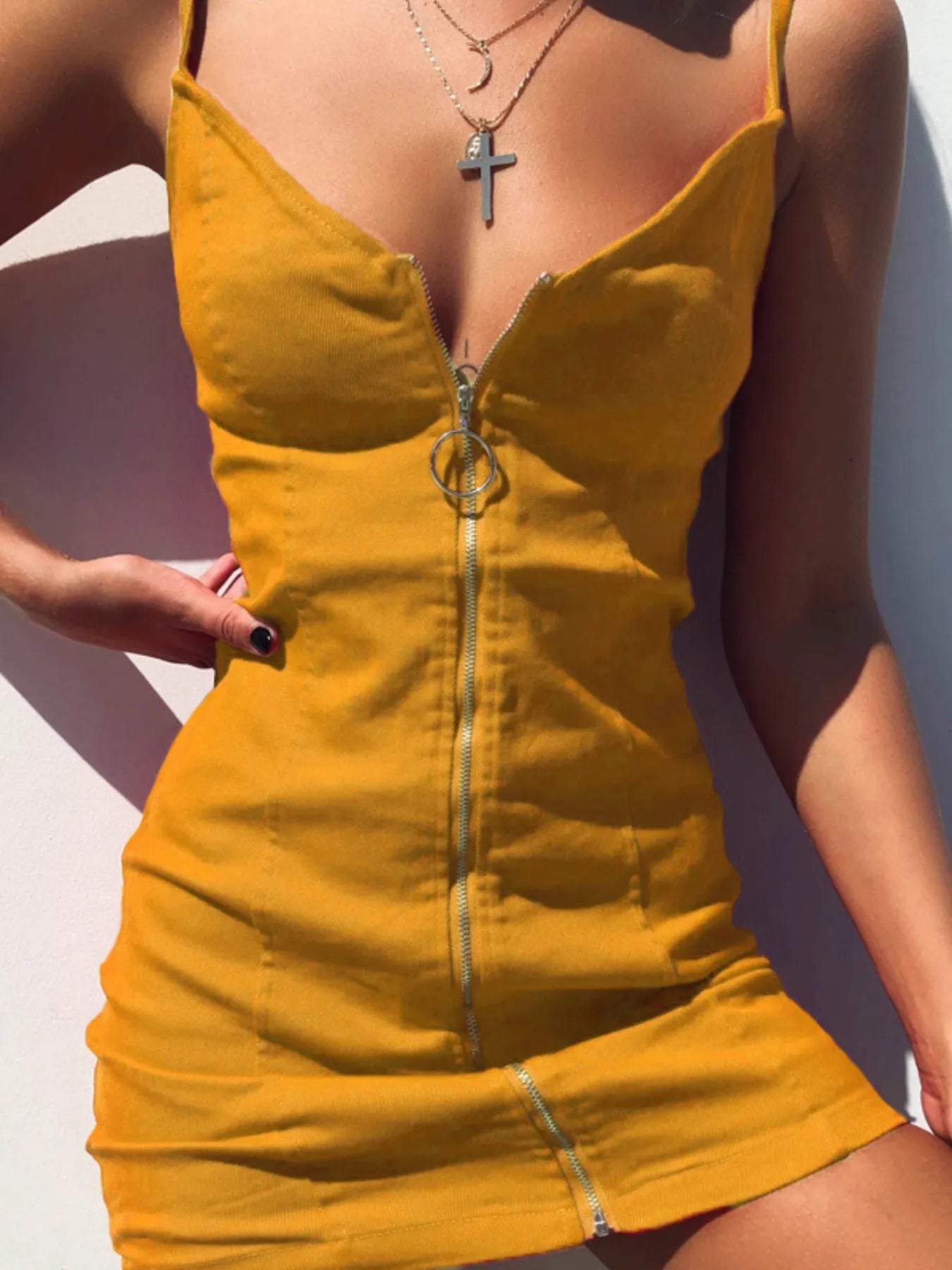 Mustard yellow zip front bodycon mini dress on model, close front view with thin straps and ring zip pull
