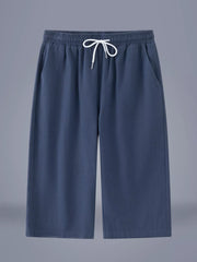 Men's dark blue cropped casual pants with a drawstring waist and pockets.