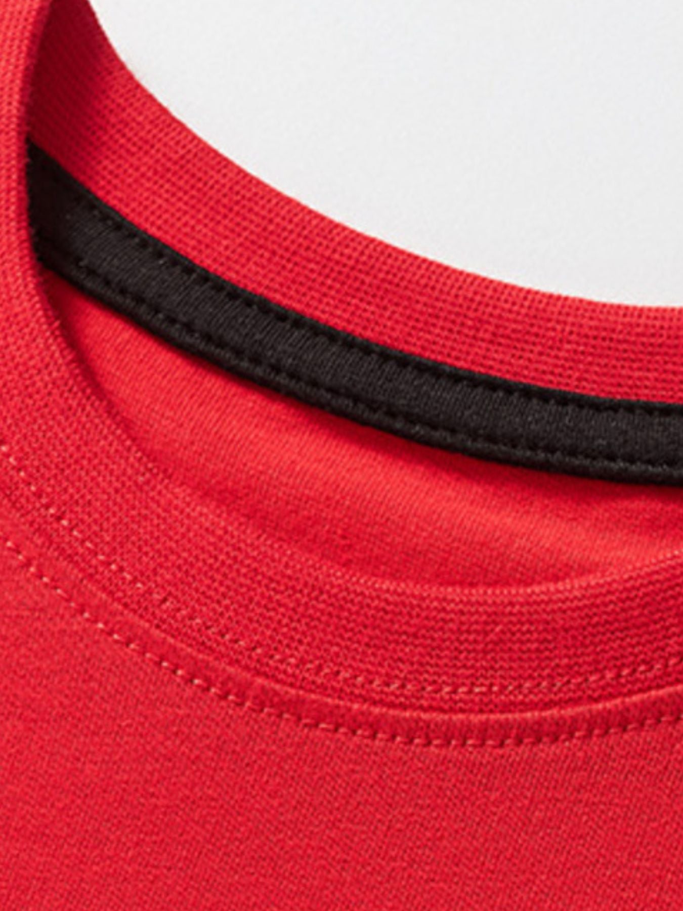 Close-up of the red ribbed neckline with black inner trim on the children's tee