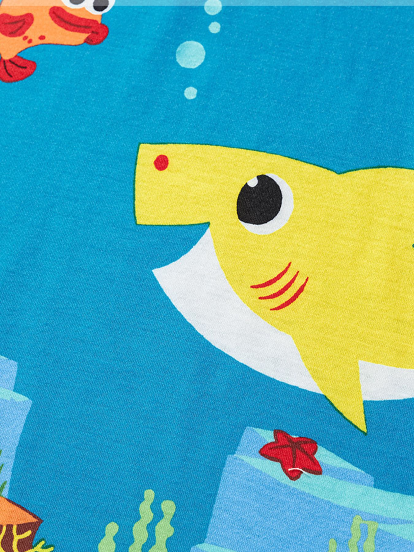 Close-up of the yellow cartoon shark and small orange fish print on sky blue fabric