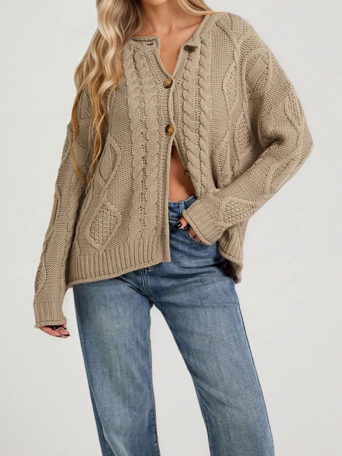 Front view of khaki cable knit button down cardigan with brown buttons and blue jeans