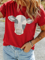 Close front view of deep red round neck casual top with patchwork cow print outdoors