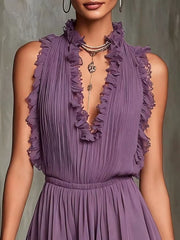 Closeup of purple sleeveless mini dress bodice showing ruffled neckline and pleated fabric