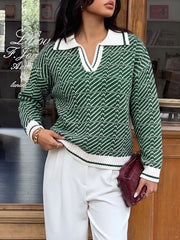 On-model front view of the green geometric sweater with a hand at the ribbed hem
