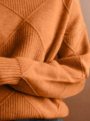 Close up of the tangerine sweater sleeve showing its diamond knit texture