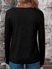 Back view of a black long-sleeve top with a wide neckline, styled with blue jeans.