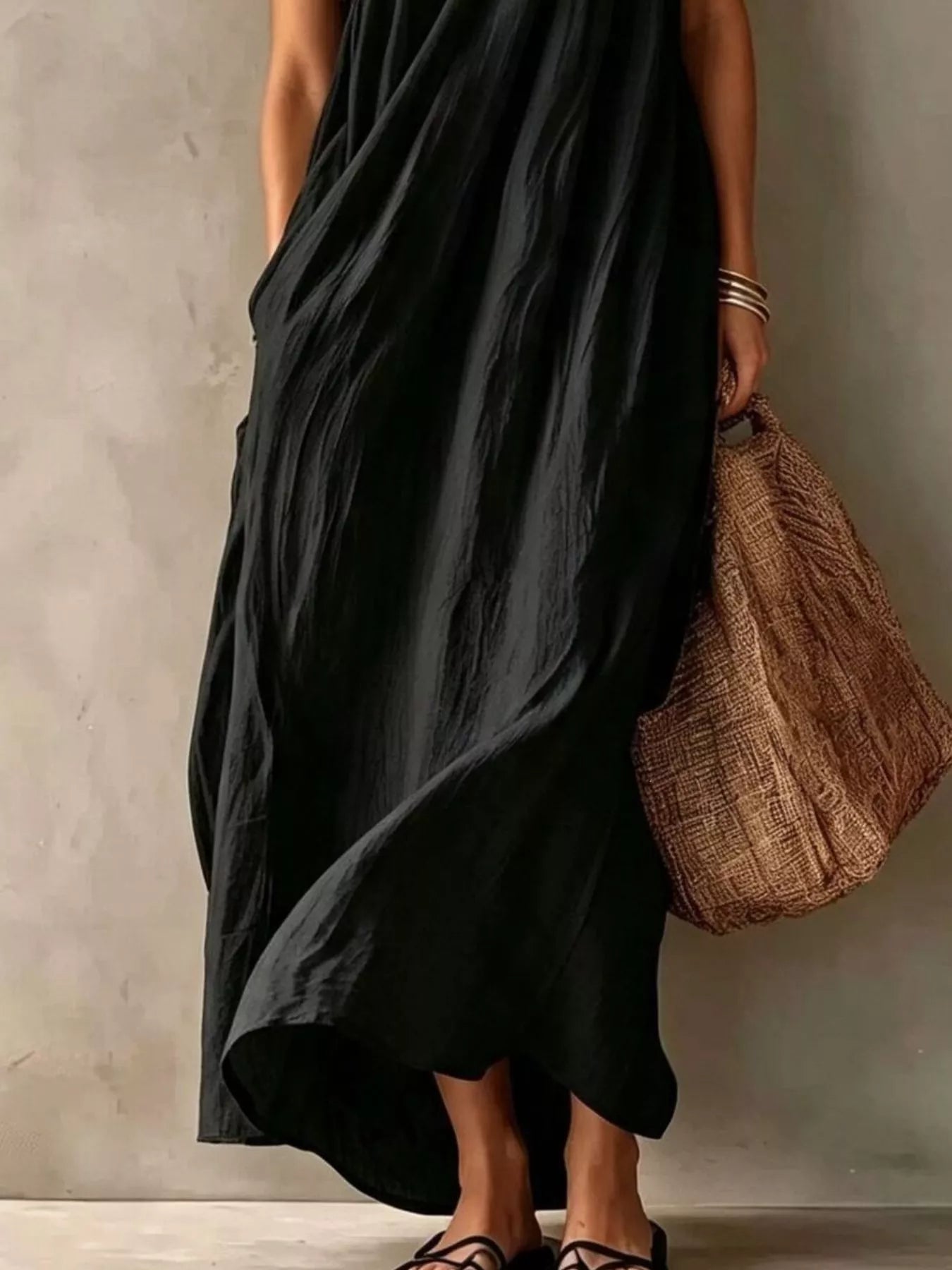 Lower view of a black one shoulder maxi dress showing the flowing skirt and hem