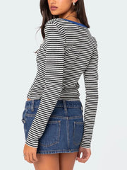 Back view of black and white striped long sleeve t shirt with royal blue neckline trim worn on model
