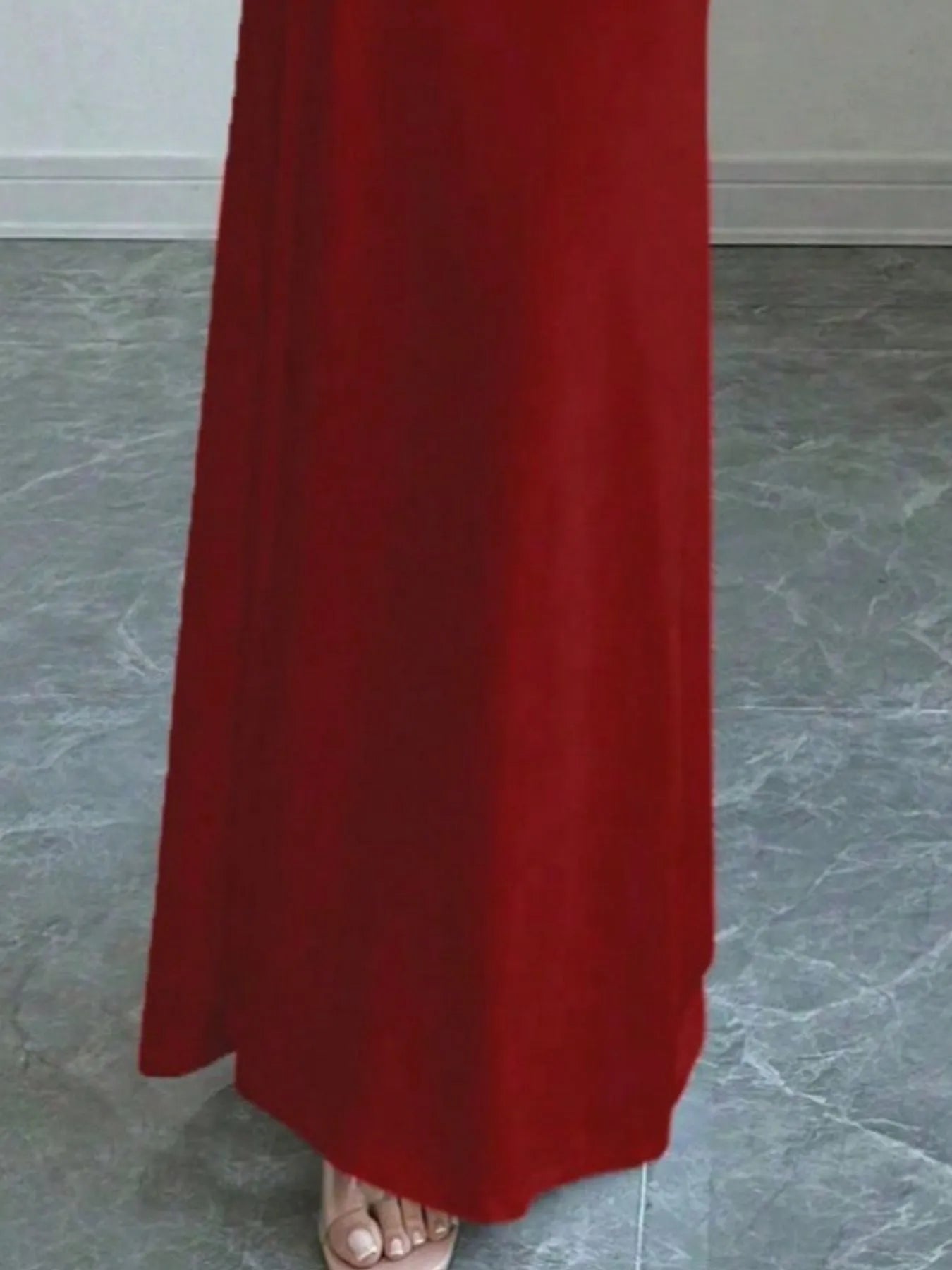 Close view of red off shoulder maxi skirt hem and floor length fabric