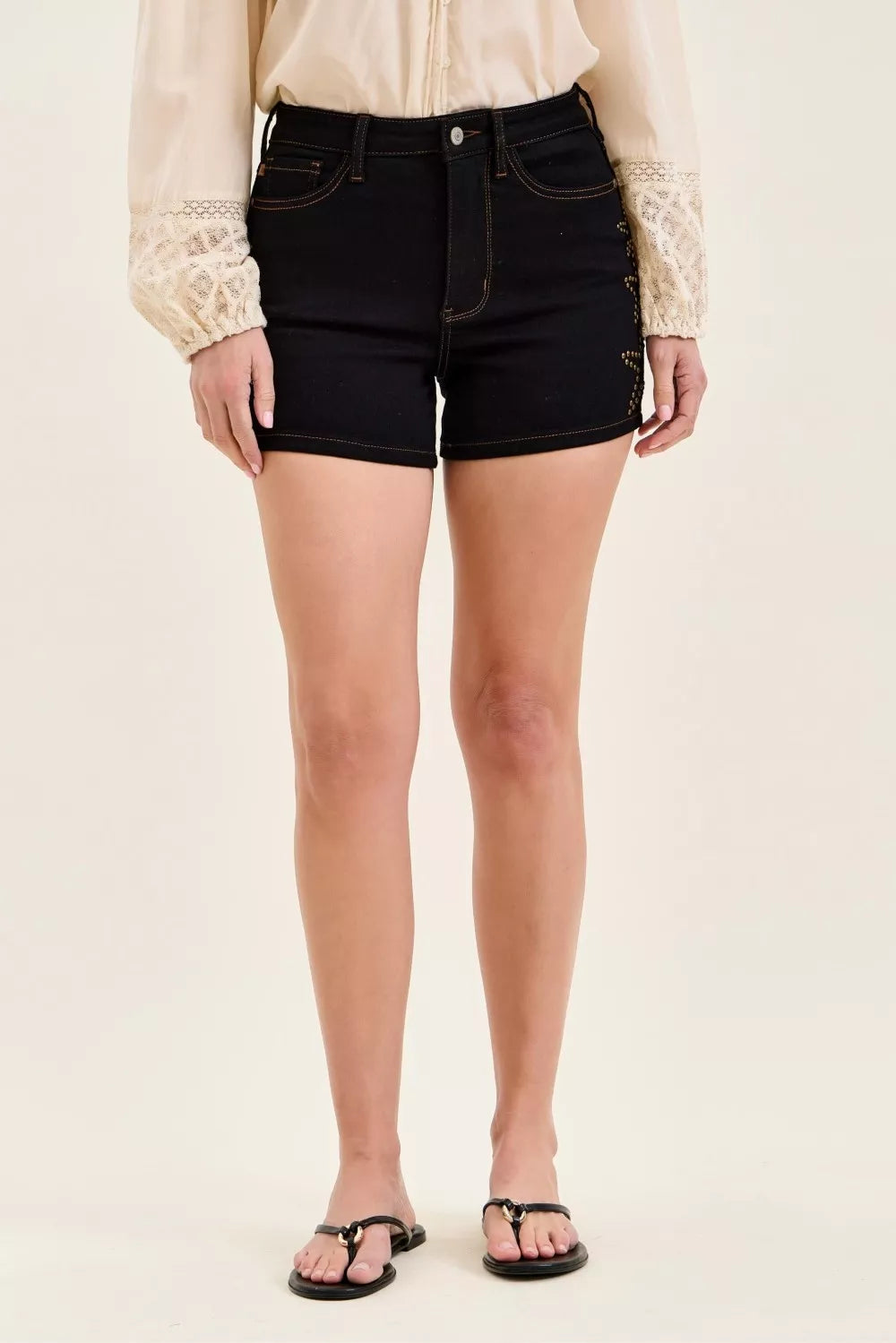Women's high-waisted slim denim shorts with star-studded detailing.