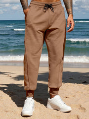 Men's brown casual joggers with a drawstring waist and pockets.