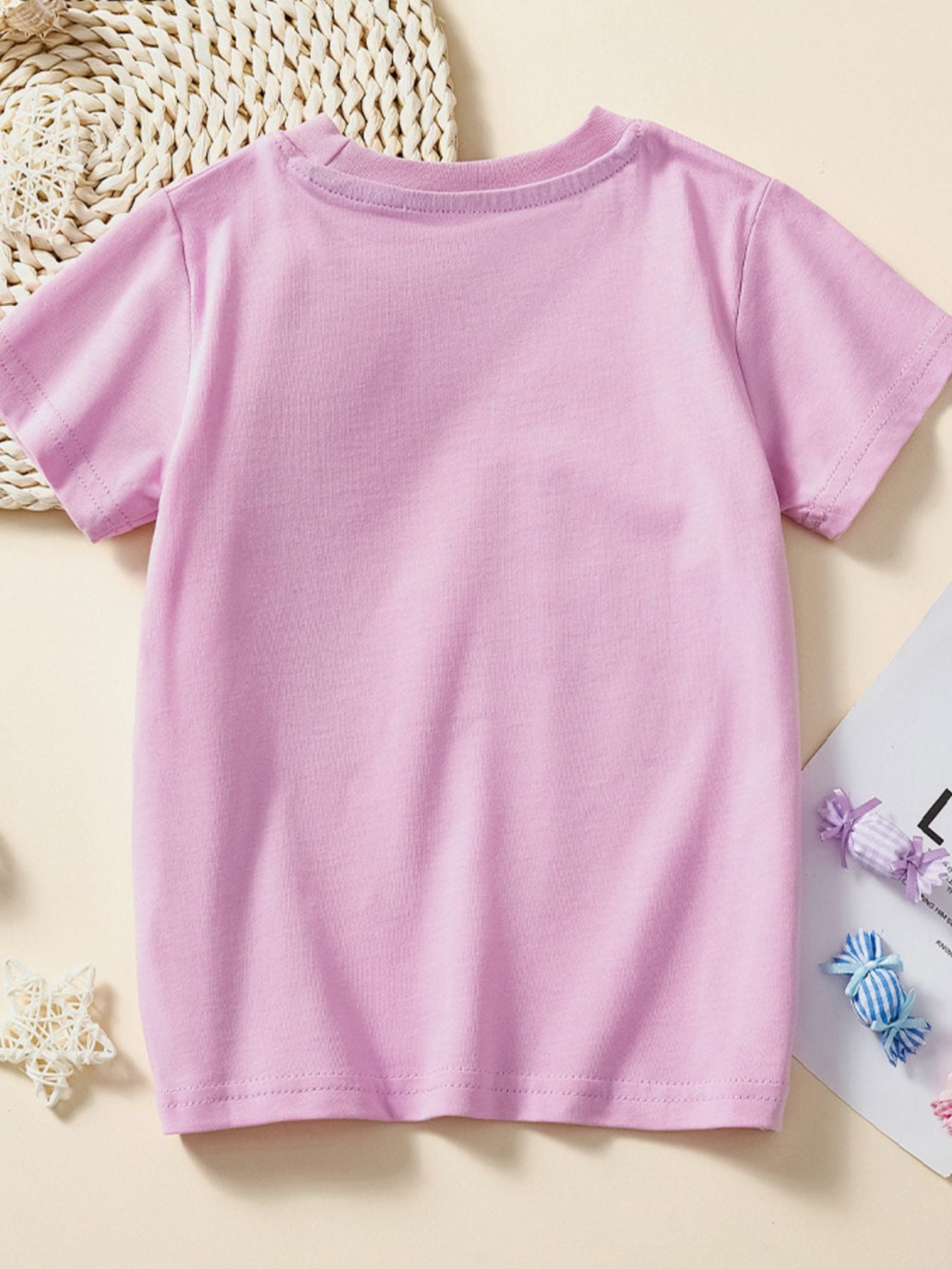 Back view of plain dusty pink children's short sleeve T-shirt laid flat