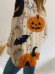 Close up side view of the beige openwork knit cover up with orange jack o lanterns and bats.