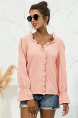 Woman wearing a peach frill-trim V-neck shirt with flounce sleeves and front button closure.