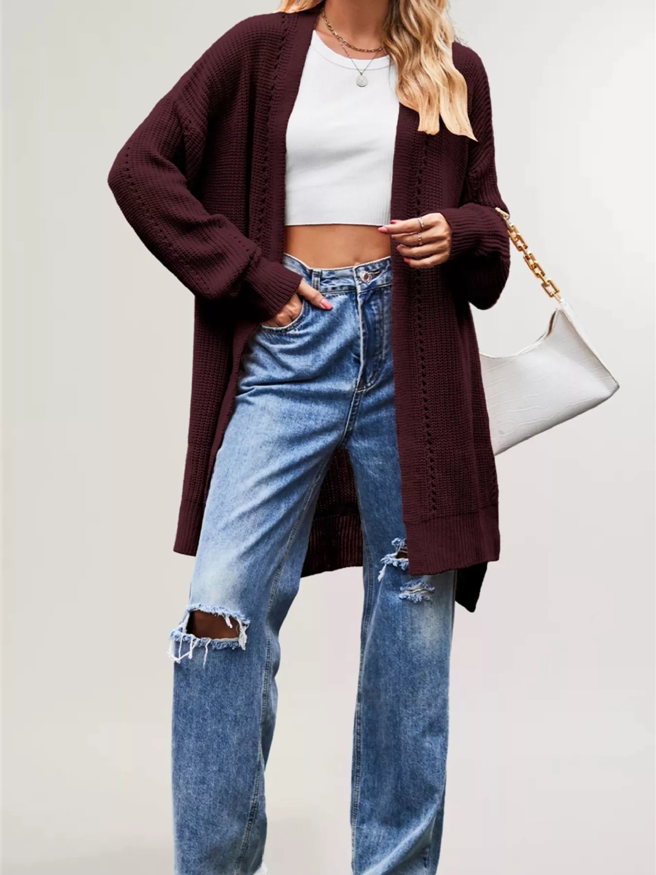 Burgundy long open front cardigan with openwork stripes worn over jeans