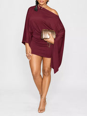 Burgundy one shoulder draped bodycon mini dress, front studio view with gold clutch