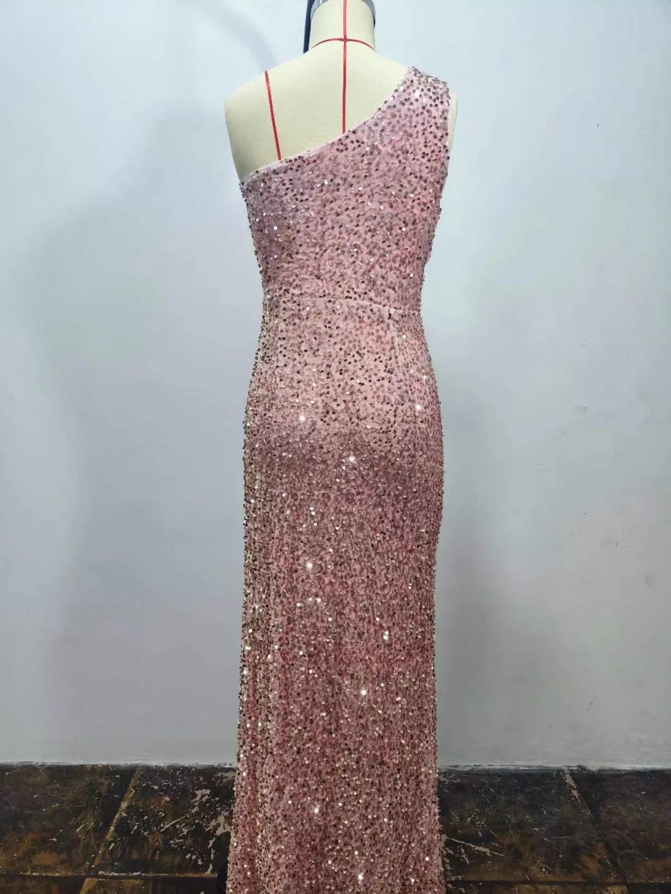 Pink sequin one shoulder evening dress shown from the back on a dress form