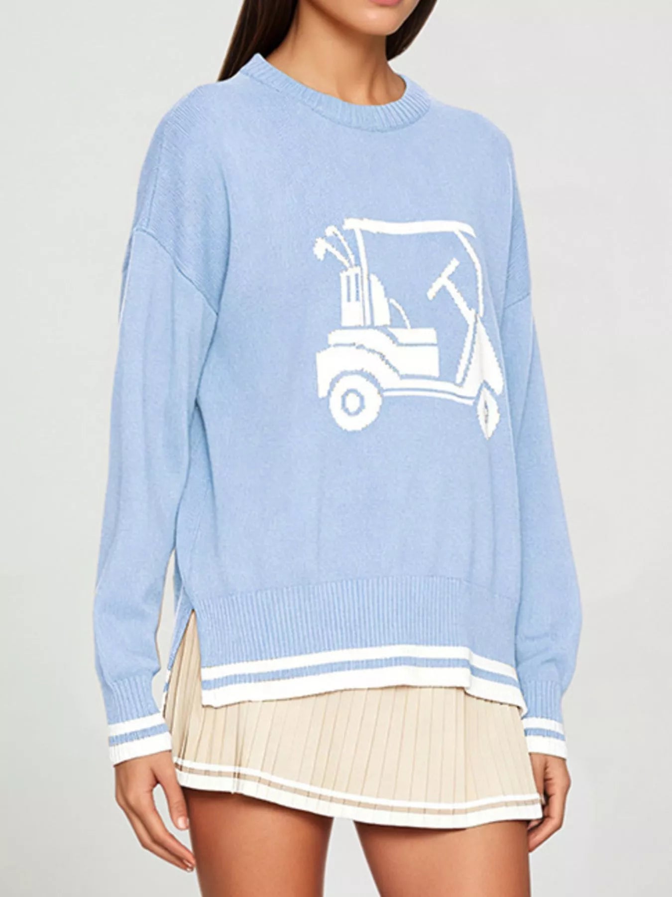 Side angled view of the light blue dropped shoulder sweater with a white golf cart graphic.