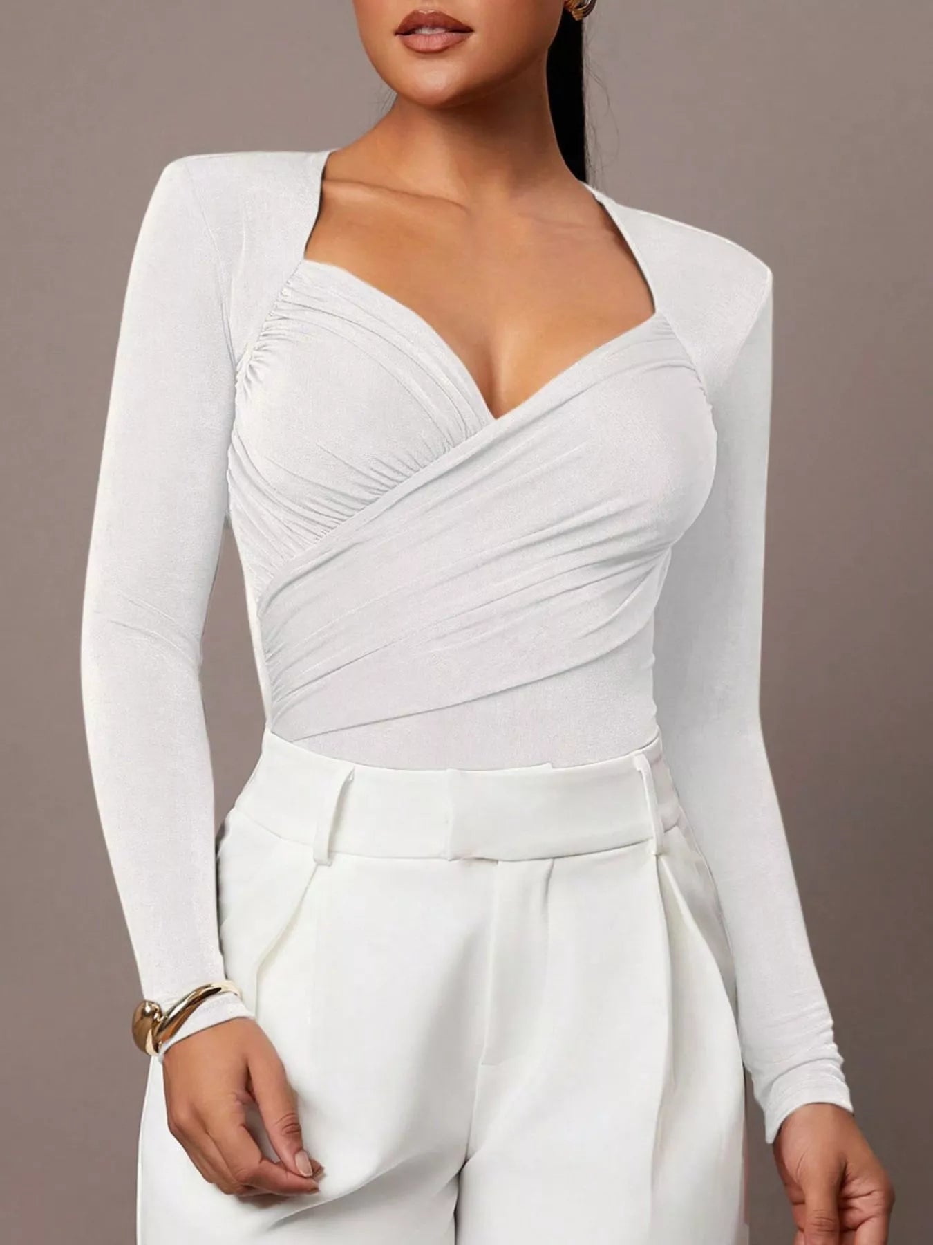 White ruched surplice long sleeve bodysuit styled with white trousers, front view