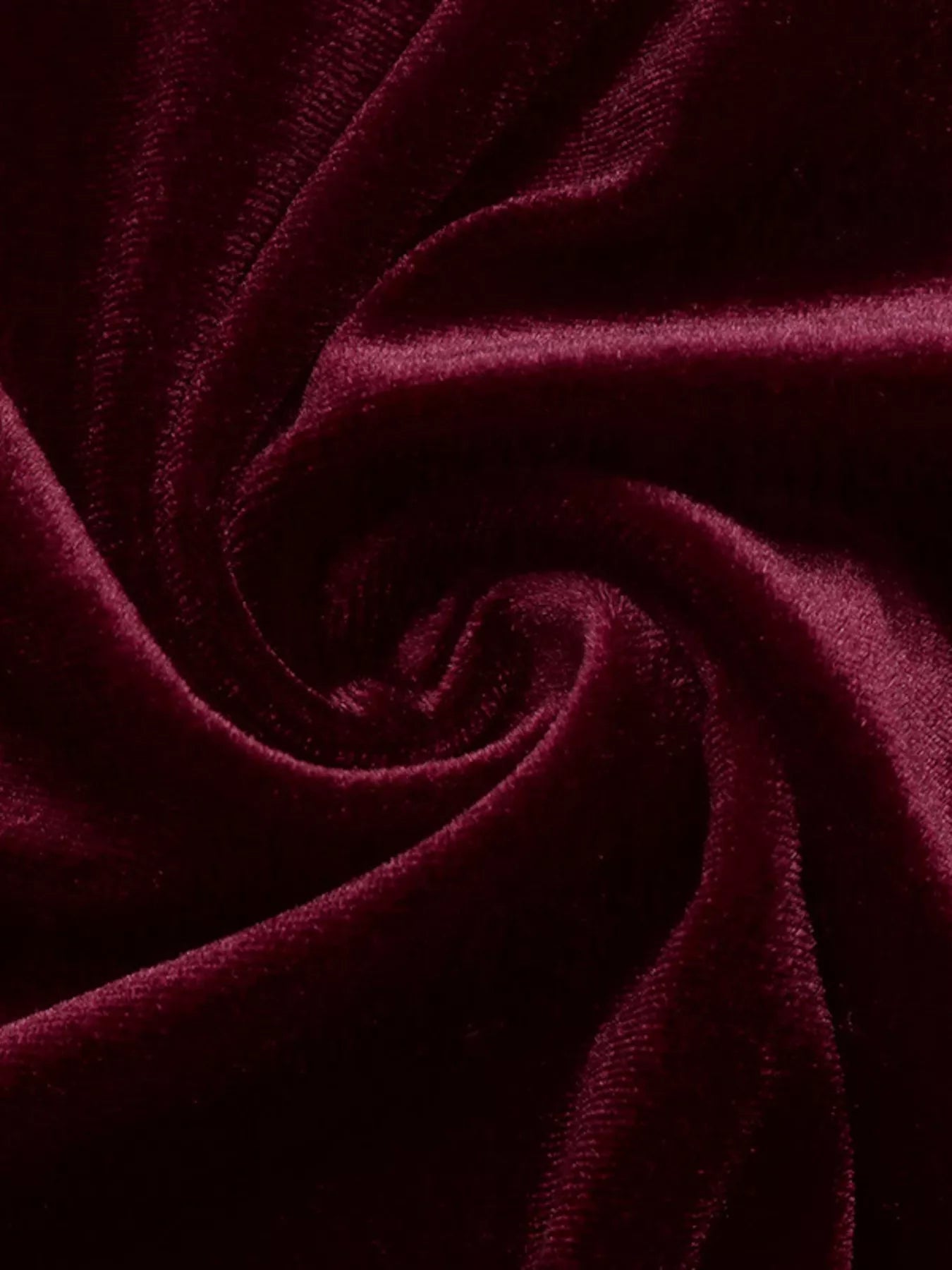 Close view of burgundy velvet fabric with soft folds from the mini dress