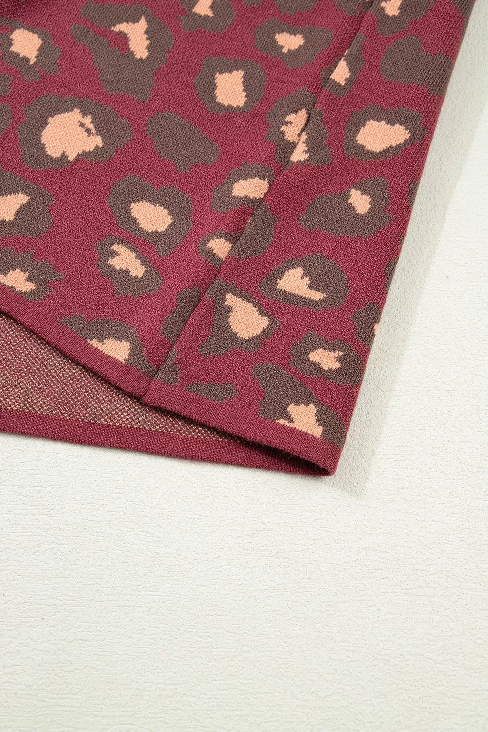 Close-up of the deep red leopard print knit top hem and lining