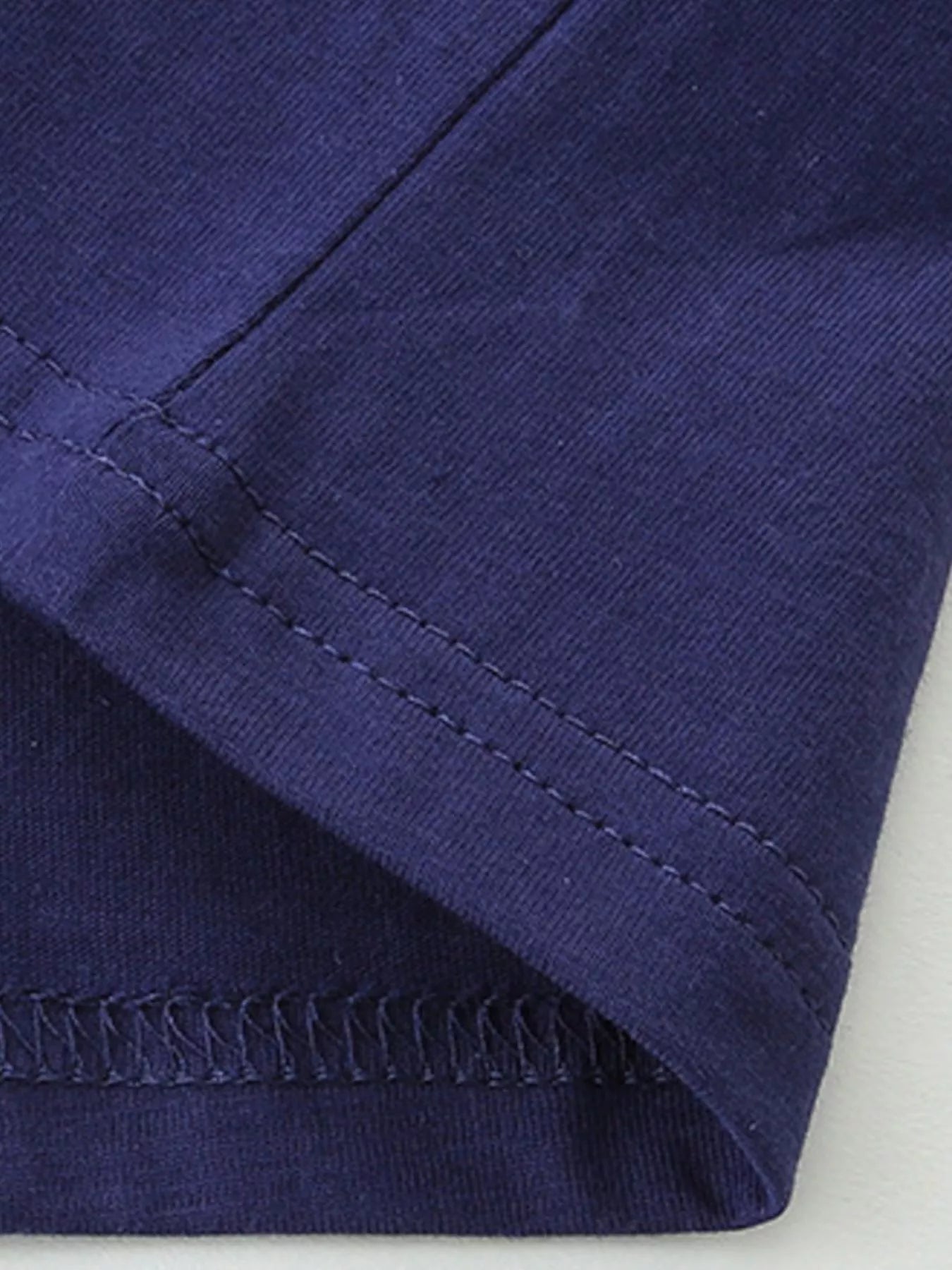 Close-up detail of the dark navy sleeve hem with double stitching and fabric texture