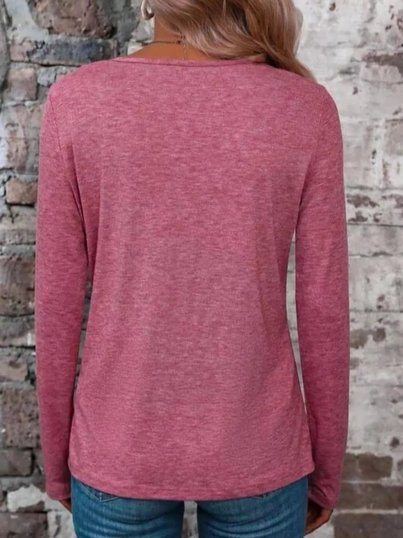 Back view of a mauve long-sleeve T-shirt worn with jeans.