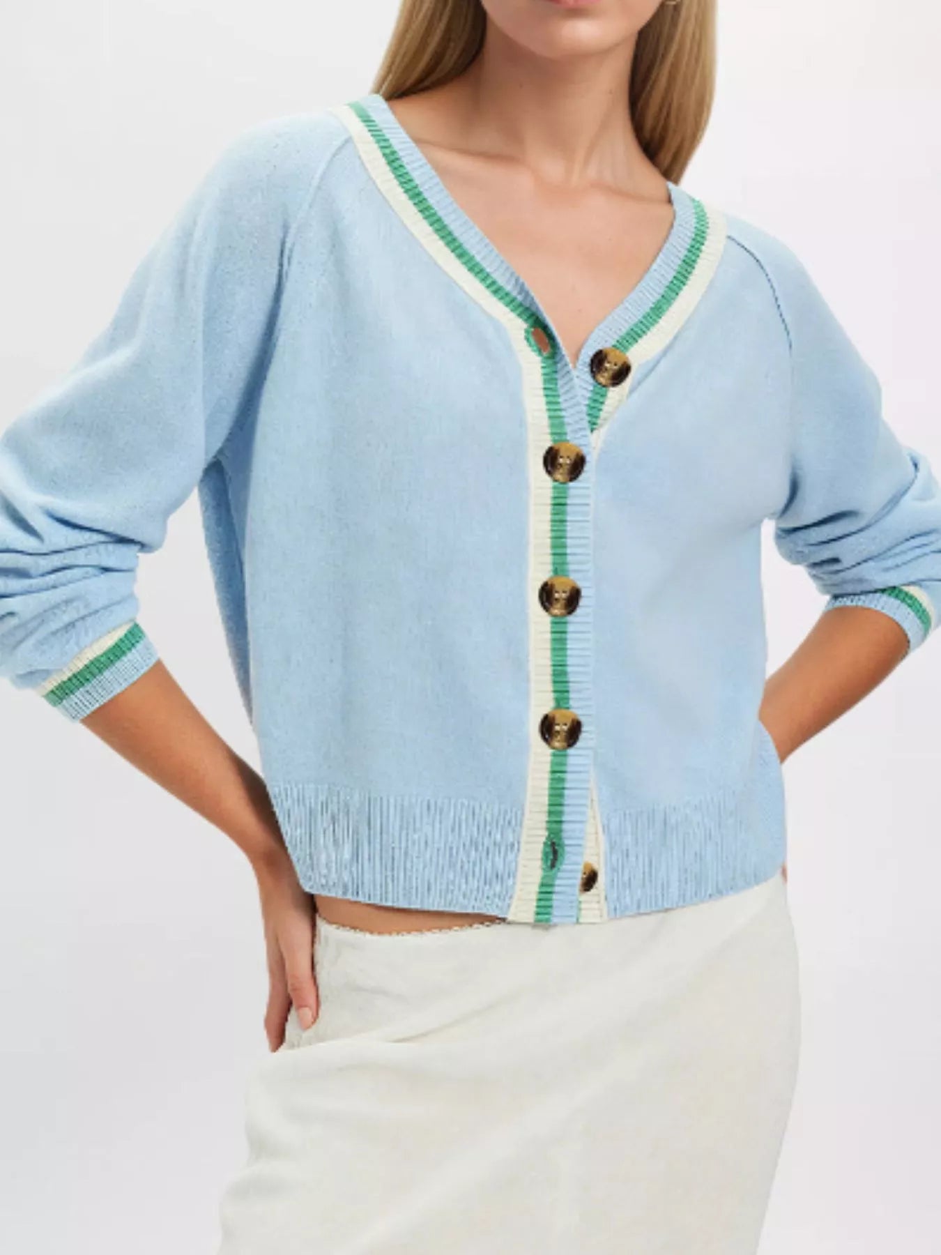 On-model front view of light blue button down cardigan with green and cream striped trim