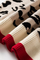 Close view of folded cream and red ribbed cuffs on a leopard print sweater.