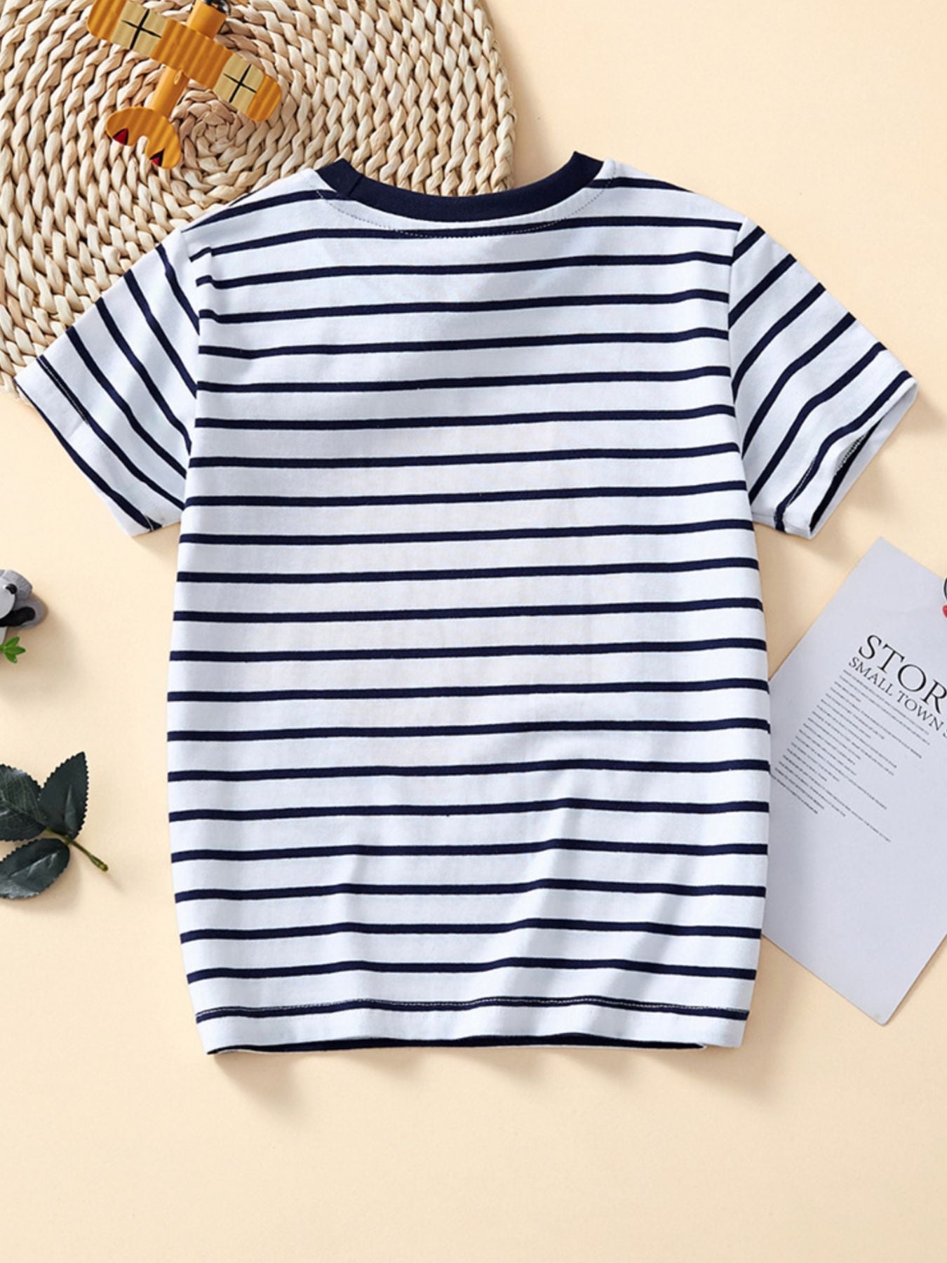 Plain back view of a white and navy striped children's crew neck T-shirt with no graphic