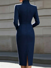 Back view of navy stand collar long sleeve midi dress with back slit outdoors