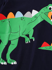 Close-up of the green dinosaur graphic with colorful back plates on a black children's short sleeve T-shirt