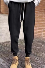 Men's black loose-fit joggers with a drawstring waist and pockets.