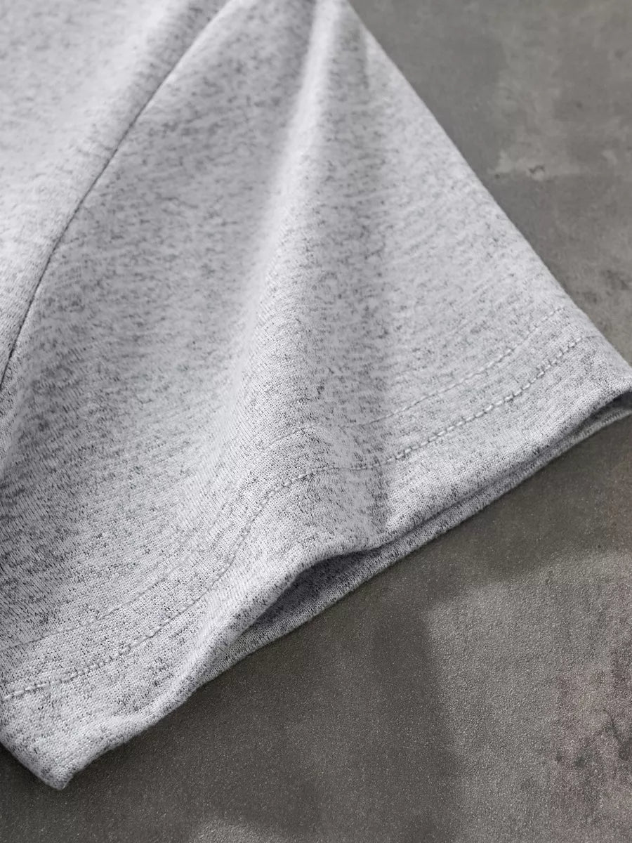 Close up of the light gray short sleeve hem and double stitching on the T-shirt