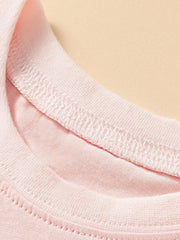 Close-up of the stitched round neckline on the blush pink children's unicorn tee