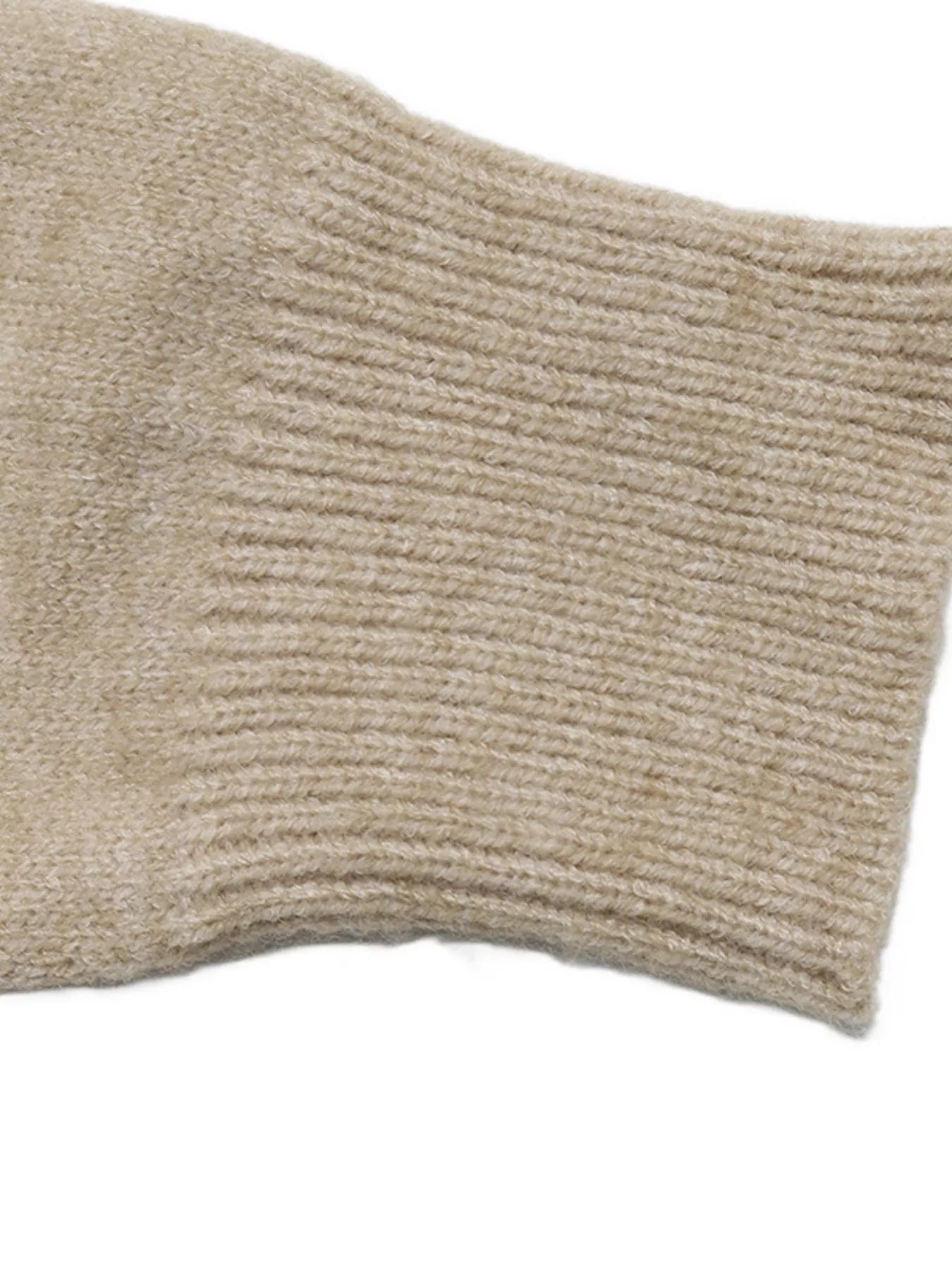 Close-up of the beige ribbed sleeve cuff on the argyle polo sweater