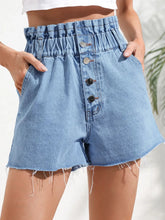 Women's denim shorts with buttons, raw hems, and pockets.
