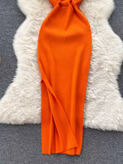 Lower skirt of orange ribbed knit midi dress showing side slit detail