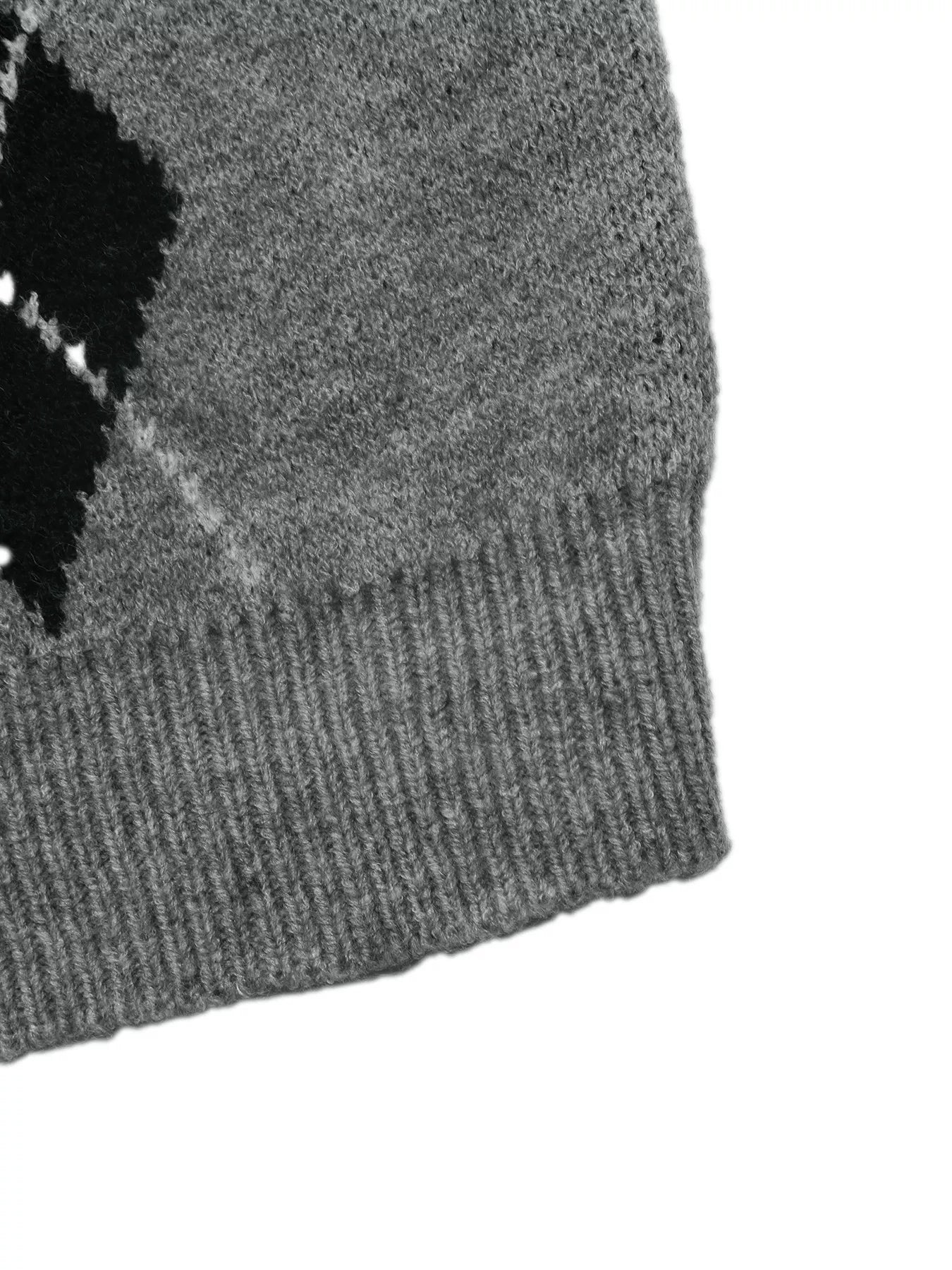 Close-up of a gray sweater hem with ribbed knit and a black argyle edge