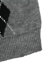 Close-up of a gray sweater hem with ribbed knit and a black argyle edge