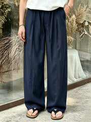 Men's wide-leg pants with a drawstring waist and pockets in the dark blue color.
