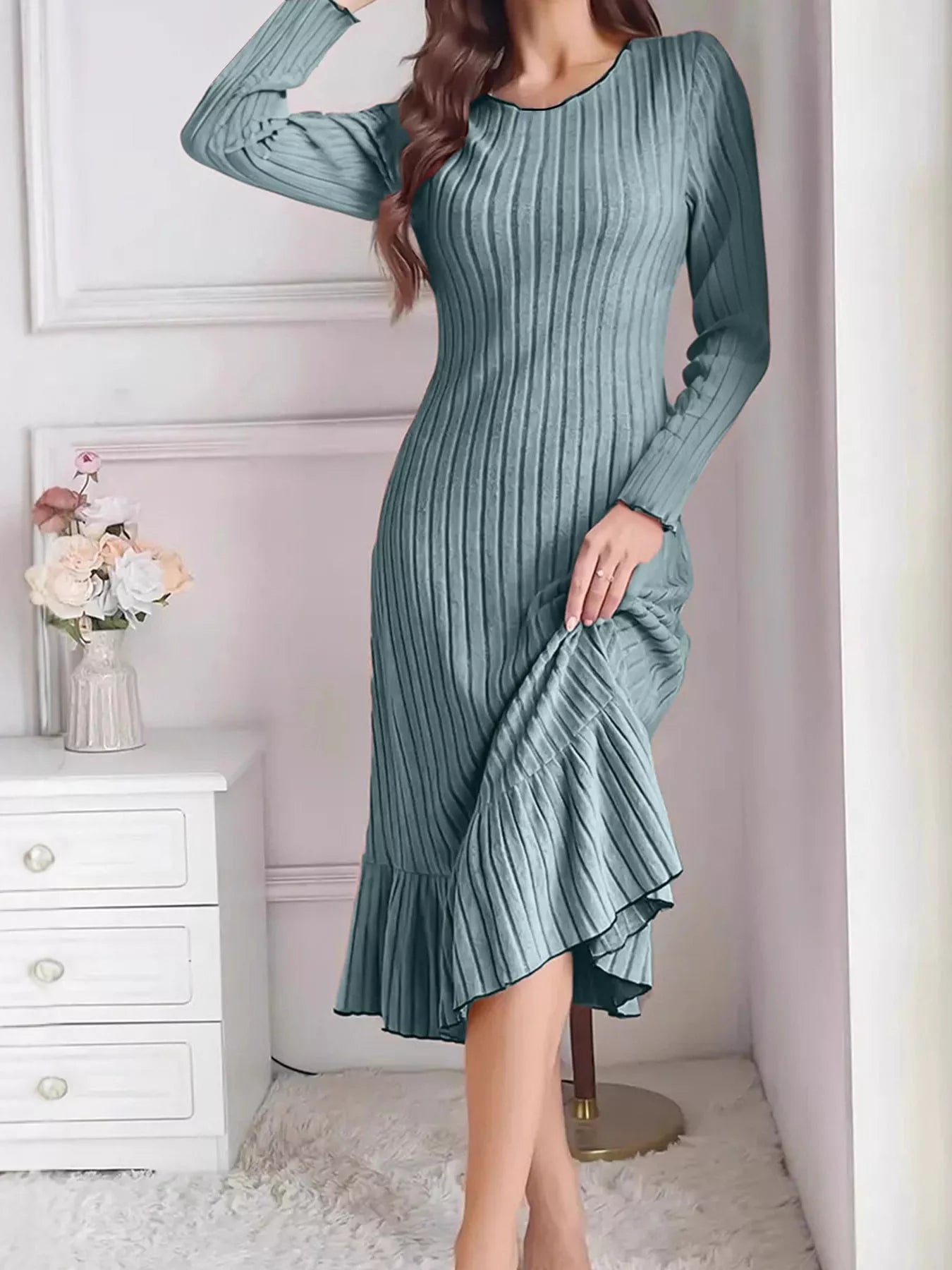 Turquoise ribbed knit bodycon dress with ruffle hem worn indoors, front view lifting the skirt