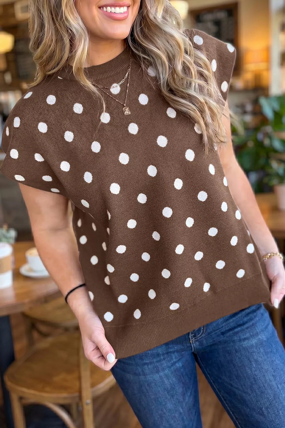 Angled front view of a brown polka dot sweater with wide short sleeves and round neck