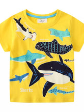 Front view of a yellow children's short sleeve shirt covered with colorful cartoon shark prints